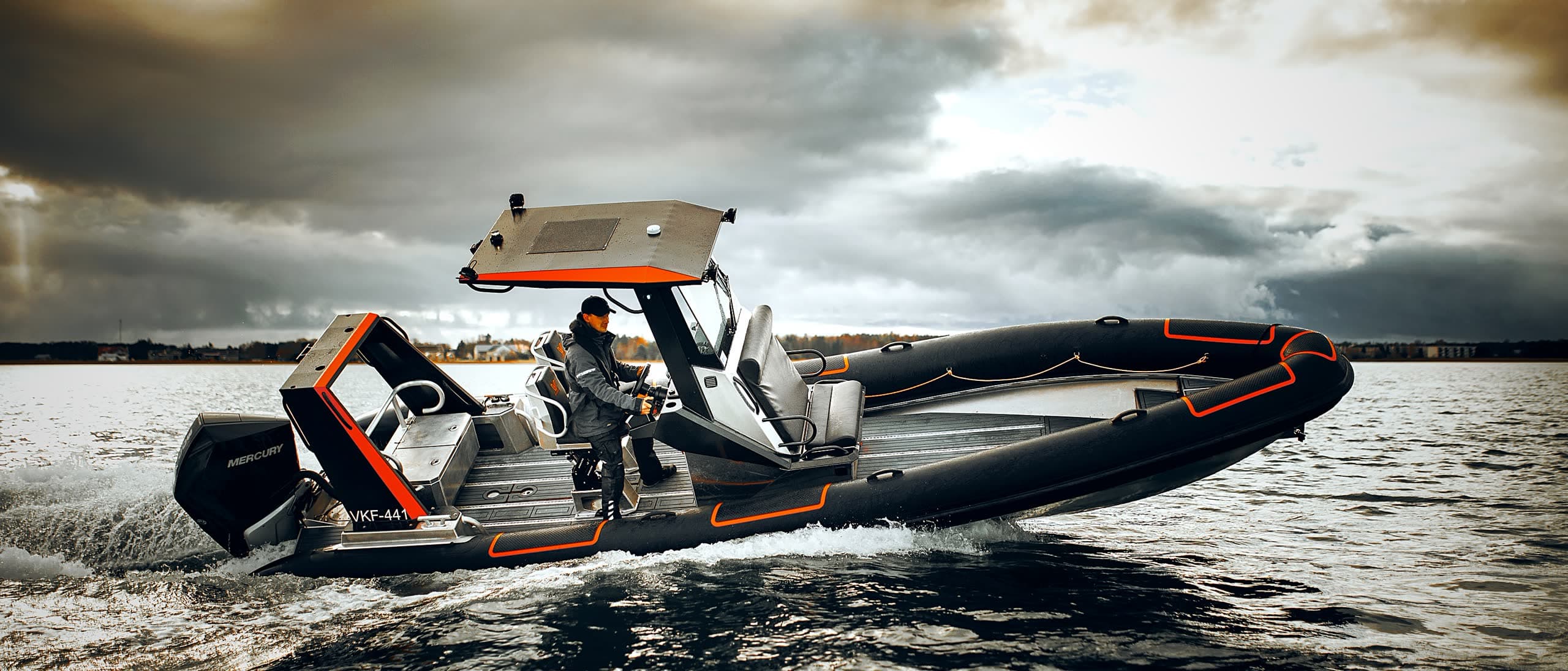 The 750 at speed under a stormy sky, helmsman at the console